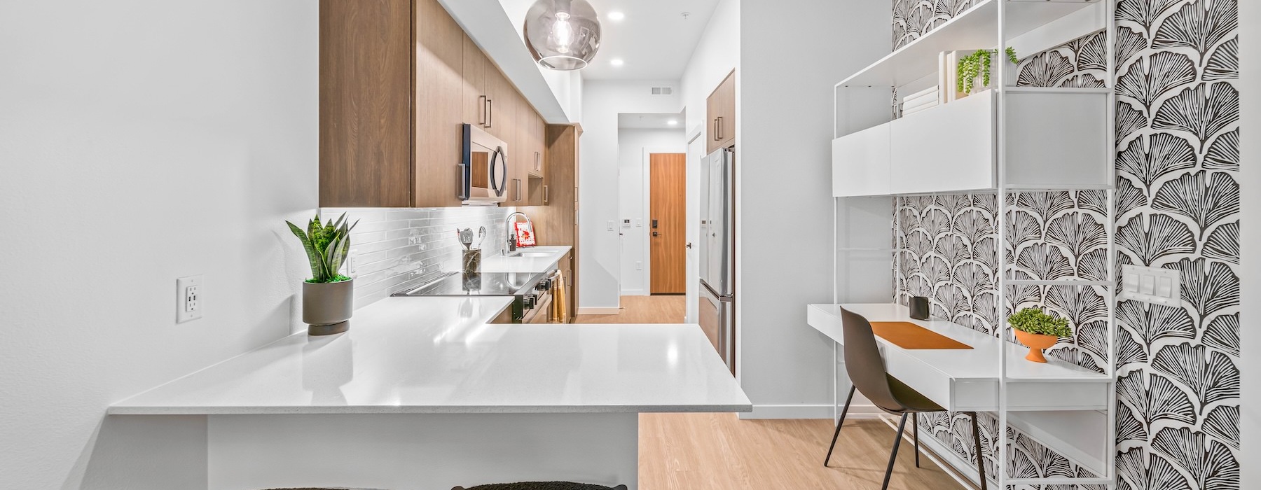 a kitchen with a white counter and a desk